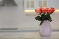 Vase with beautiful roses on white marble kitchen table, space for text. Interior design Royalty Free Stock Photo