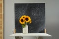 Vase with beautiful sunflowers and double-sided backdrop on table in photo studio Royalty Free Stock Photo