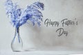 Vase of blue reeds on wood board with happy father\'s day text. Royalty Free Stock Photo