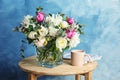 Vase with bouquet of beautiful flowers and cup on table Royalty Free Stock Photo