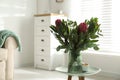 Vase with bouquet of beautiful Protea flowers on table at home