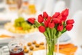 tulips on festive table. serving table with appetizers, canapes, salads in jars Royalty Free Stock Photo