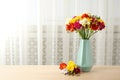 Vase with bouquet of spring freesia flowers in room Royalty Free Stock Photo