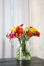 Vase with bouquet of spring freesia flowers on table Royalty Free Stock Photo