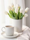 Vase with bouquet of white tulips and cup of cappuccino.