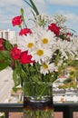 Vase of colorful, cut flowers with green, narrow leaves