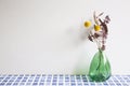 Vase of dry flowers on blue ceramic mosaic tile table. white wall background Royalty Free Stock Photo