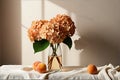 A vase filled with flowers and peachs on a table Royalty Free Stock Photo
