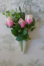 Vase, flower vase, small wall vase from the 50s with three artificial pink roses in front of a nostalgically patterned wallpaper,