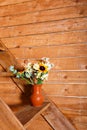 Vase with flowers bouquet on the stairs with wooden background