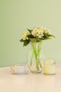 Vase of flowers and teacup in soft green pastel hues Royalty Free Stock Photo