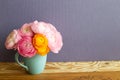 Vase of fresh ranunculus flowers on wooden table