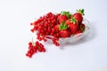 A vase of fruit with strawberries and red currants and several berries on a white background Royalty Free Stock Photo