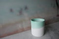 Vase, mug, candle. ceramic container in front of pastel-colored background Royalty Free Stock Photo