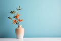 a vase with orange flowers sitting on a table in front of a blue wall Royalty Free Stock Photo