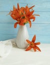 Vase orange lily retro bouquet holiday blooming composition design on a wooden background textiles