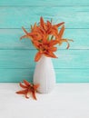 Vase orange lily decoration plant retro blooming composition on a wooden background