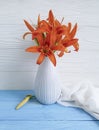 Vase orange lily retro holiday composition nostalgia on a wooden background textiles