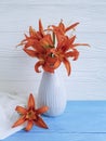 Vase orange lily retro holiday on a wooden background textiles