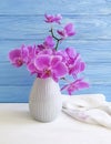 Vase orchid flower on wooden background congratulation, blue, fresh, spring