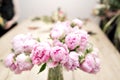 Vase of peonies in the foreground. soft focus. Workshop florist, making bouquets and flower arrangements. Woman Royalty Free Stock Photo