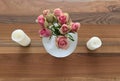 A vase of pink and cream roses with candles either side Royalty Free Stock Photo