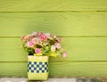 Vase with Plastic flowers and green wall Royalty Free Stock Photo
