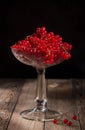 Vase with red currant on a wooden table on a black background Royalty Free Stock Photo