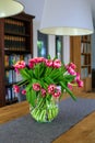 Vase with red tulips on a table in living room Royalty Free Stock Photo