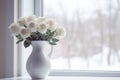 Vase with white beautiful roses on windowsill in room. Snowing city window view