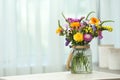 Vase with wild flowers on table