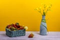 Vase with wildflowers. A basket of strawberries. One strawberry is on the table. Summer time Royalty Free Stock Photo