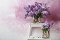 Vases with blossoming lilac on step ladder