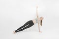 Vasisthasana. Side Plank Pose. Young woman with slim body doing cardio aerobic exercises. Attractive woman doing yoga on white