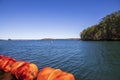 vast blue rippling water at Lake Lanier with large orange buoys in the water and lush green trees with rocks along the banks Royalty Free Stock Photo