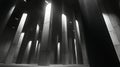 A vast, dimly-lit interior space features numerous tall, rectangular concrete pillars with a smooth texture Royalty Free Stock Photo