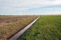 Vast Dutch polder landscape intersected by a ditch