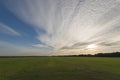 Vast grass land with evening sky and clouds