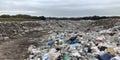 Vast landfill stretching across an open field highlighting environmental waste issues Royalty Free Stock Photo