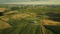 A vast landscape is dotted with wind turbines generating renewable energy for use in biofuel production. This innovative