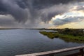 Vast miles of lush green marsh surrounded by deep blue ocean water with powerful clouds at sunset at Bolsa Chica Reserve