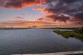 Vast miles of lush green marsh surrounded by deep blue ocean water with powerful clouds at sunset at Bolsa Chica Reserve