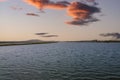 Vast miles of lush green marsh surrounded by deep blue ocean water with powerful clouds at sunset at Bolsa Chica Reserve