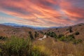 Vast open mountain range landscape covered with dry brush and green trees with blue sky at Chino Hills State Park