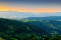 Vast panorama view of foggy valley in the Owl Mountains with silhouette of Sudetes mountain range at dusk. Poland.