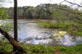 A vast rippling river in the forest surrounded by lush green trees and plants with gray sky at Murphey Candler Park