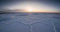 Vast salt flat surface with hexagonal patterns under a soft sunset sky Royalty Free Stock Photo