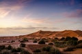 Vast sand dunes of Erg Chebbi with colorful sunrise. Sahara desert landscape with purple sky in Morocco