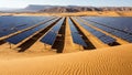 Vast solar panel array stretching across a desert landscape with rolling sand dunes and distant arid mountains under a clear blue Royalty Free Stock Photo
