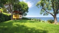 A Vast Spring Backyard with Lush Green Grass, Ocean Views, and a Cheerful Yellow Kids\' Tree House Playground Royalty Free Stock Photo